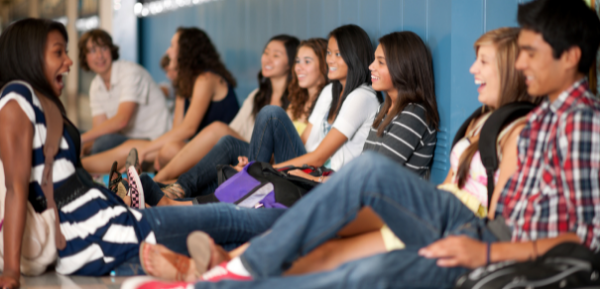 Teens sitting in school hallway